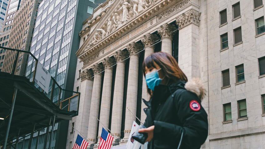 A person wearing a face mask walks past the New York Stock Exchange in New York, New York, USA, 27 January 2020.