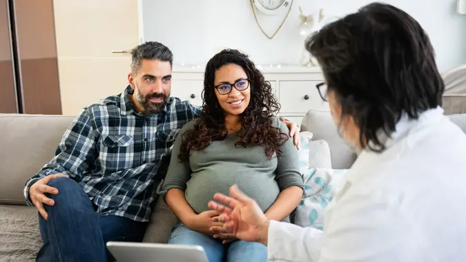 Doctor visit pregnant woman at home.