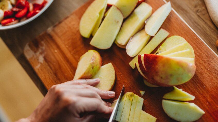 Woman cutting fruit in the kitchen.