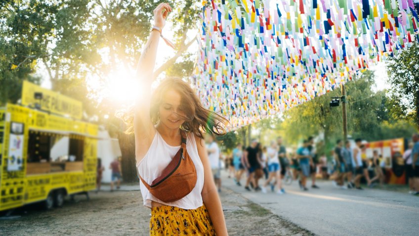 Young Caucasian woman in yellow skirt having fun on music festival in summer.
