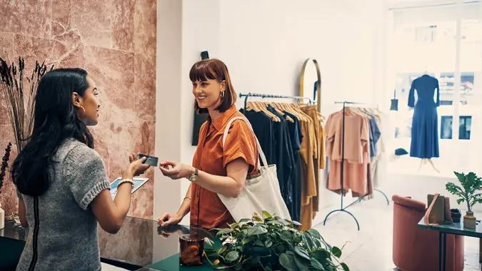 Shot of a customer paying with a credit card in a clothing store.