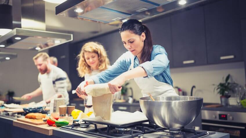 Chef is supervising attendees of cooking class while they are making meals.