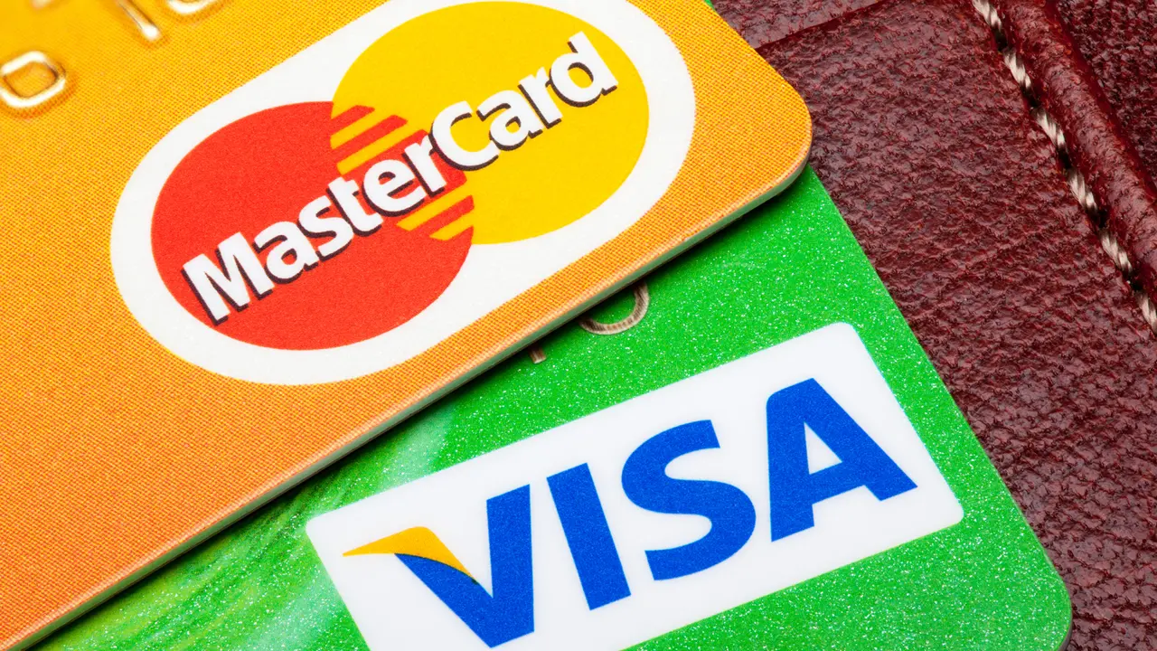 Tallinn, Estonia - September 24, 2014: Visa and Mastercard credit cards with the leather wallet on the background.