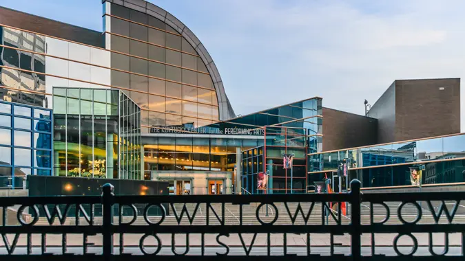 Louisville, Kentucky, USA - March 27th 2016: Kentucky Center for the Performing Arts building in Louisville Kentucky with rod iron fence which states "Downtown Louisville" in foreground.