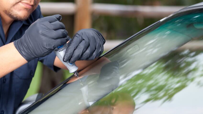 Man repairing and replacing the glass on a car.