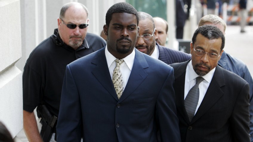 Atlanta Falcons football player Michael Vick arrives with his attorney Billy Martin, right, at federal court.