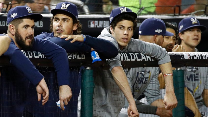 Milwaukee Brewers' Christian Yelich, third from left, sits in the dugout in the fifth inning of a National League wild card baseball game against the Washington Nationals, in WashingtonBrewers Nationals Baseball, Washington, USA - 01 Oct 2019.