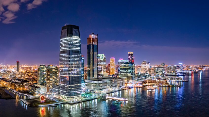 Aerial panorama of Jersey City skyline at night.