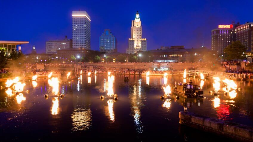 "Providence, Rhode Island, USA - June 30, 2011: A boat of volunteers, clad all in black, kick off the last Waterfire of July 2011 by lighting the first brazier.