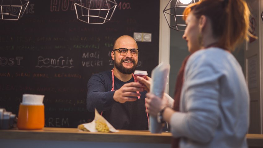 Charming Man Serving Fresh Coffee To Pretty Young Girl.