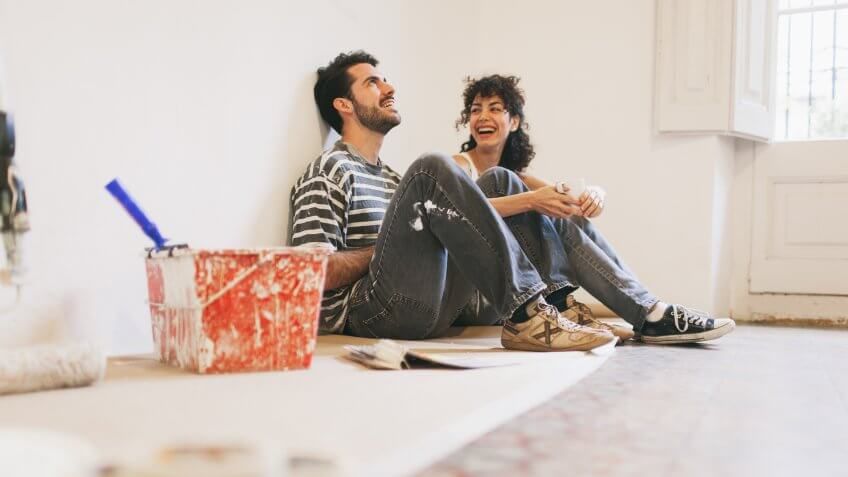 Couple is resting and having fun after hard work painting their apartment.