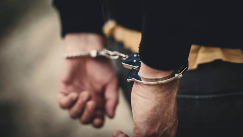 Man in handcuffs behind his back.