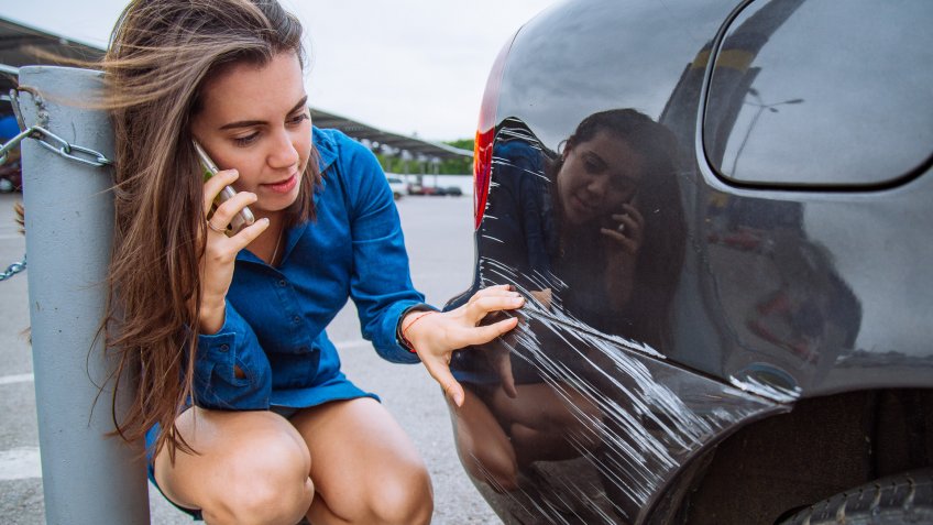 woman stand near scratched auto.