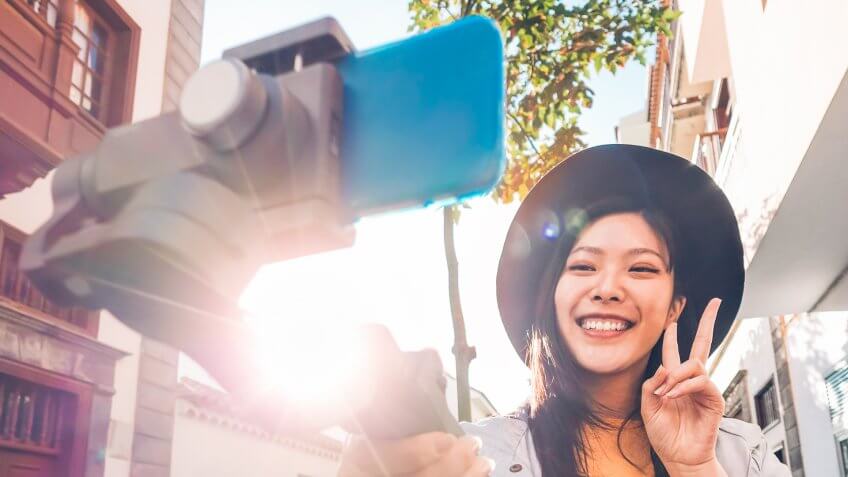girl using selfie stick recording a video