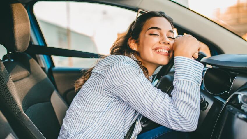 Young Woman Embracing Her New Car.