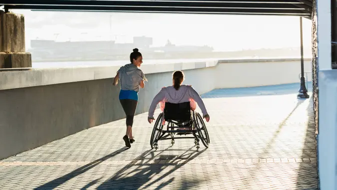 Rear view of two friends exercising along a city waterfront.