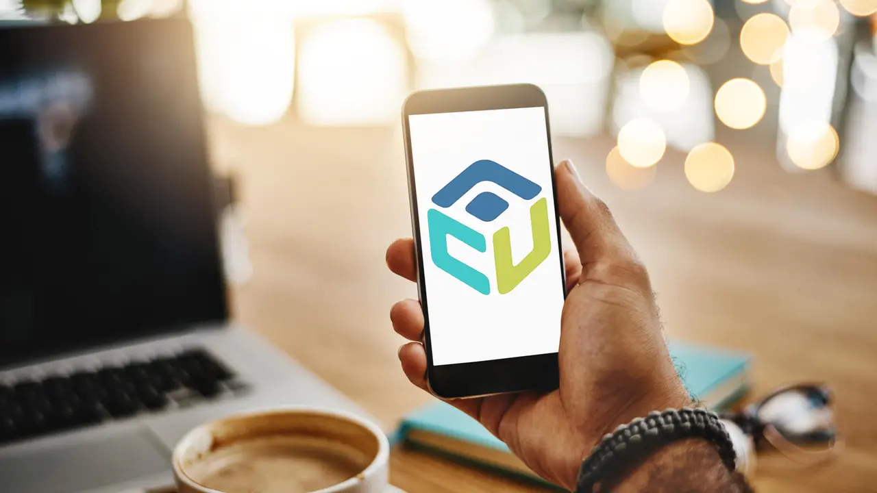 Closeup shot of an unrecognizable man holding up a cellphone with a blank screen in a cafe.