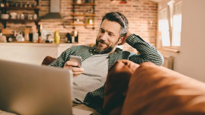 Close up of a young man using a phone at home.
