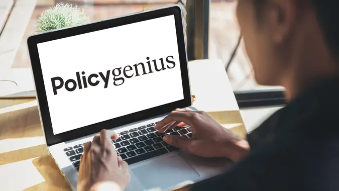 Young man working on his laptop with blank copy space screen for your advertising text message in office, Back view of business man hands busy using laptop at office desk.