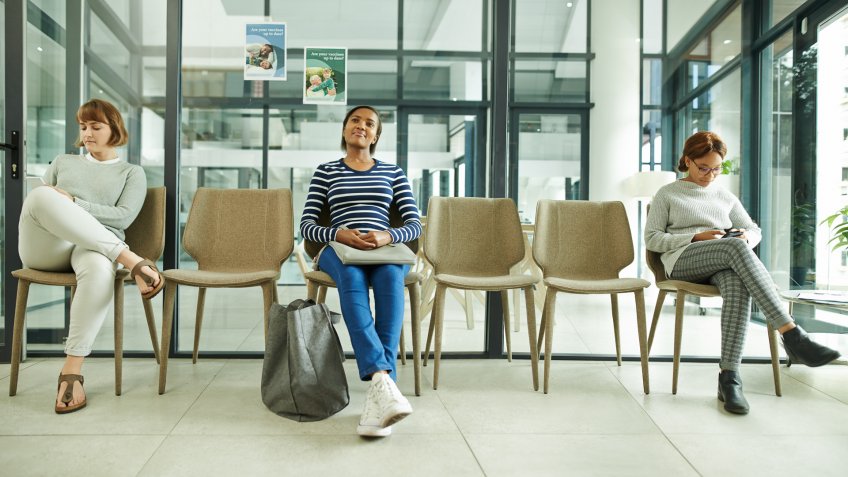 Shot of a group of young women sitting in the waiting room of a clinic.