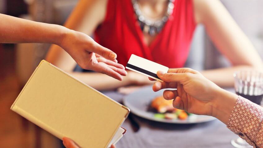 Picture showing people paying in restaurant by credit card reader.