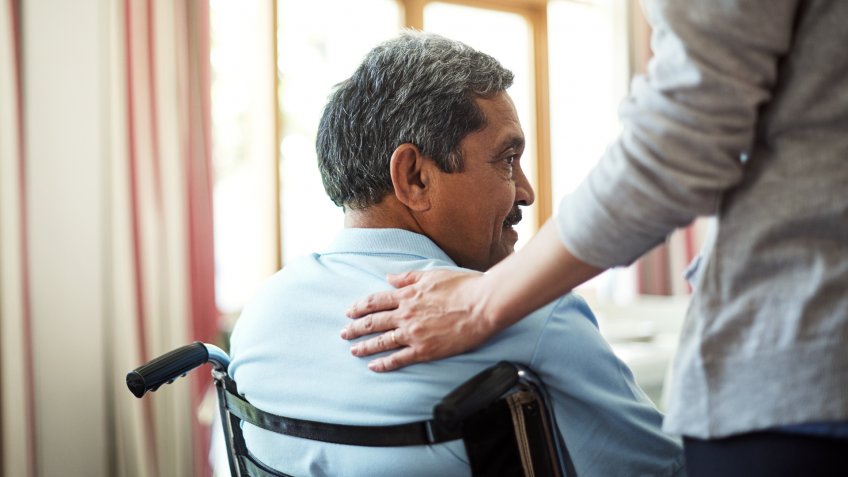 Shot of a young nurse caring for a senior man in a retirement home.