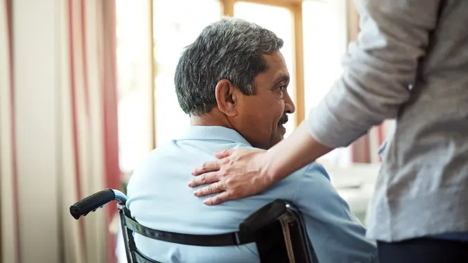 Shot of a young nurse caring for a senior man in a retirement home.