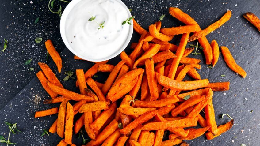 Healthy Homemade Baked Orange Sweet Potato Fries with fresh cream dip souce, herbs, salt and pepper.