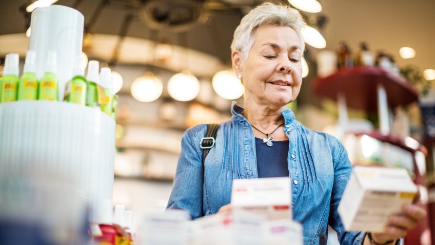 Beautiful senior woman buying medicine at chemist.