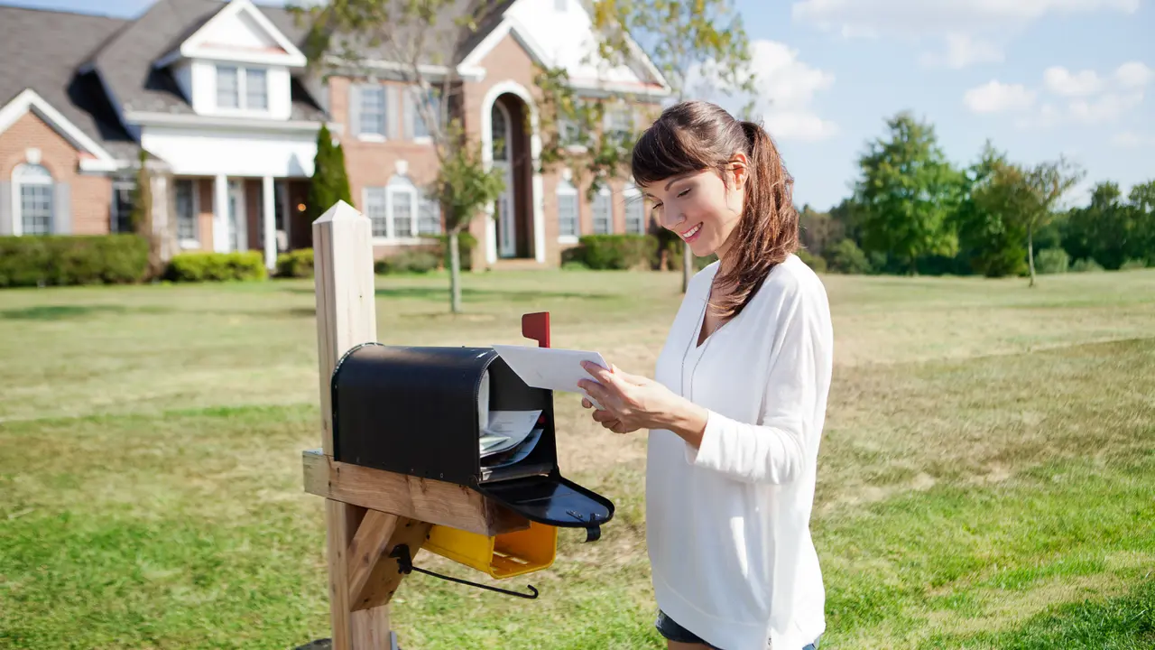 Beautiful american housewife checking mail box.