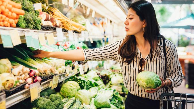 asian local woman buy vegetables and fruits in supermarket.