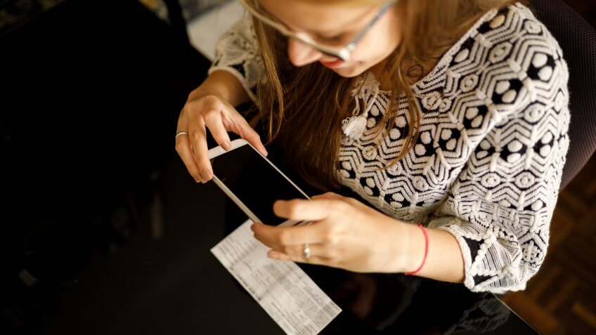 Woman depositing check by phone.