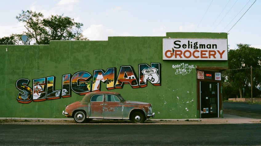 Seligman, Arizona - May 28 2019: Seligman Grocery, with a painted sign and vintage care, on Route 66.