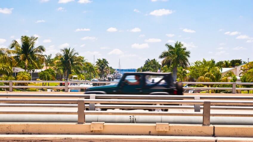 Car speeding over a canal bridge in southern Florida.