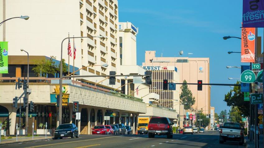 Fresno, United States - March 8, 2015: Downtown Fresno Street Scene, looking down Van Ness Avenue, with a Radisson Hotel, and several office buildings in the scene, and cars in the lower part of the view, and banners on the side of the street advertising Downtown Fresno.