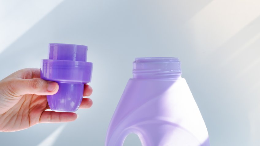 woman hand using liquid laundry softener detergent washing cloth.