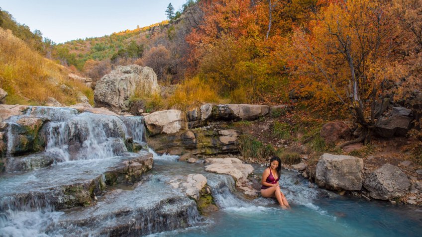Woman relaxing at Fifth Water Hot Springs in Utah, USA during autumn.