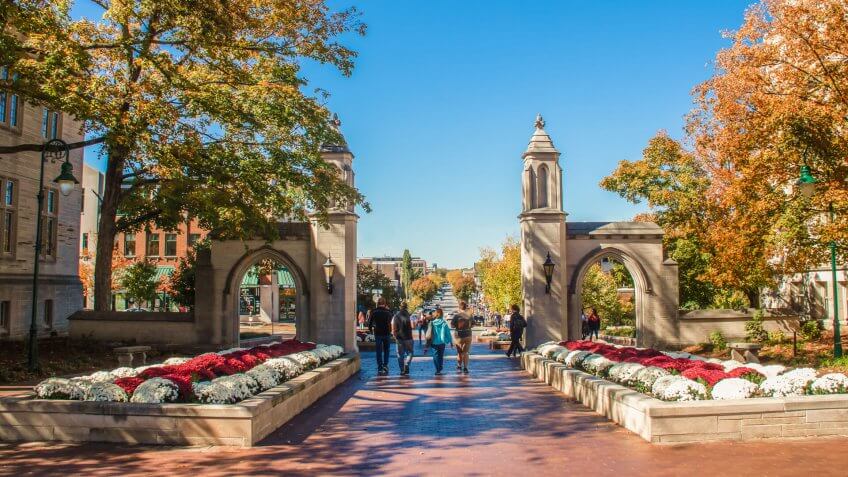 10-19-2019 Bloomington USA - University of Indiana - Family walks with college student out main gates of campus down into the town during Fall Break weekend.