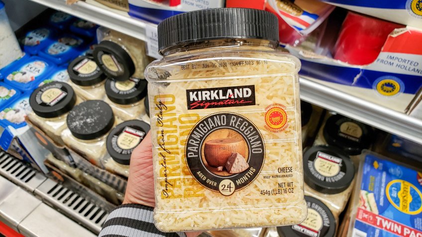 Alhambra, California/United States - 01/31/2020: A hand holds a container of Kirkland Signature grated parmigiano reggiano cheese on display at a local Costco.