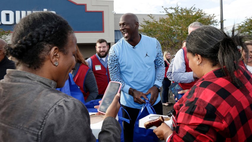 Charlotte Hornets owner Michael Jordan greets people and hands out food for Thanksgiving to members of the community in Wilmington, N.