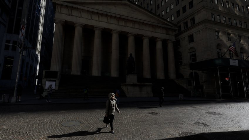 A person walks along a nearly empty Wall Street near the New York Stock Exchange in New York, New York, USA, on 18 March 2020.