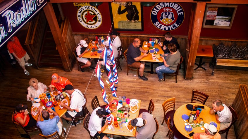 Looking down at people eating, drinking and checking phones at Eskimo Joes bar and resturant near OSU Stillwater Oklahoma USA 05 02 2018.