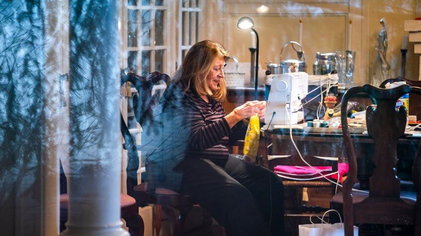 Pat Roth, pictured through her living room window, sews homemade face masks which she donates to George Washington University Hospital in Washington, DC, USA, 28 March 2020.