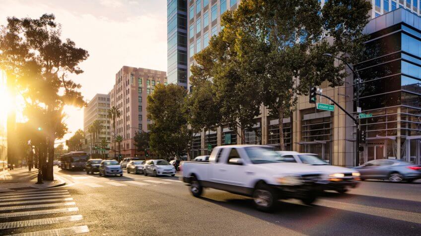 Downtown San Jose at rush hour with sunset and moving traffic.