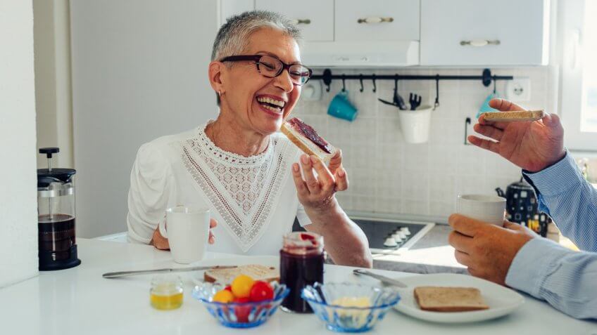 Senior couple having breakfast and talking in the kitchen.