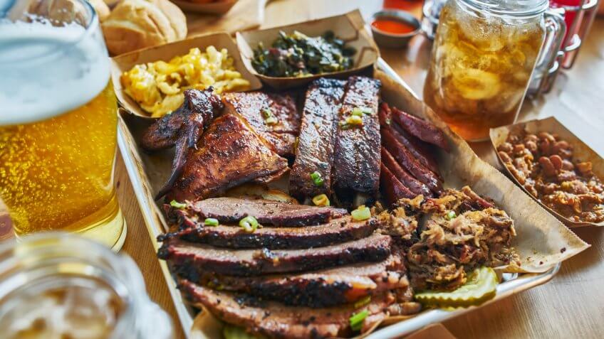 texas style bbq tray with smoked brisket, st louis ribs, pulled pork, chicken, hot links, and sides.