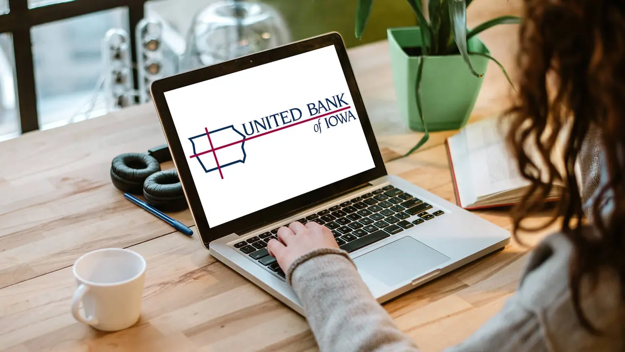 Woman working on laptop with white screen in modern office.