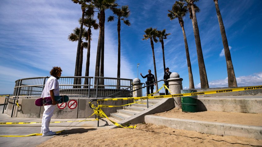 LAPD officers ask a skater to leave the closed skatepark next to the beach amid the coronavirus pandemic in Venice, California, USA, 28 March 2020.