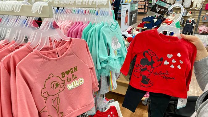 San Jose, CA - November 23, 2019: Young woman looking through clothes on rack at Walmart store.