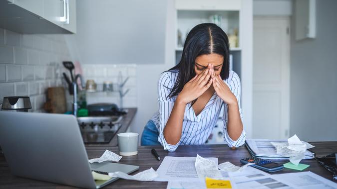 Cropped shot of an attractive young businesswoman standing alone and feeling stressed while going through her finances in her home.